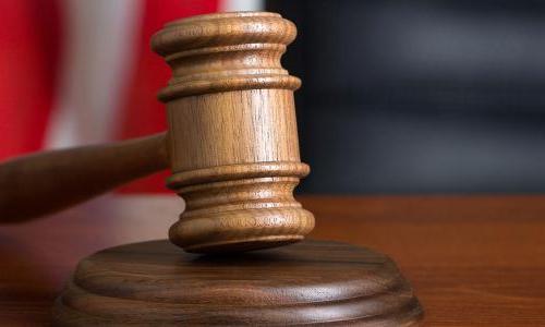 Gavel resting on bench with American flag in background 